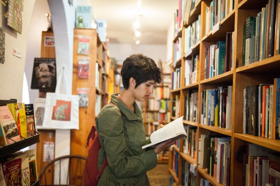 Student, Mission resident and frequent customer Haley Grey, 17, looks for a good read at Adobe Books & Arts Cooperative on a recent afternoon. (Photo by Ekevara Kitpowsong/ Bay News Rising) 