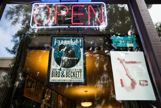 Posters promoting live jazz and an in-house gallery festoon the front window of Bird & Beckett Books and Records in Glen Park. (Photo by Ekevara Kitpowsong/ Bay News Rising)