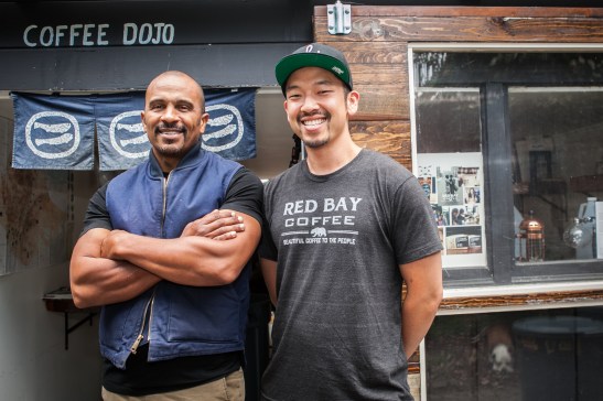 (L-R) Founder and chief executive officer of Red Bay Coffee company Keba Konte, 48 and chief operations officer Kori Chen, 31, stand in front of Garden Coffee Dojo, the company's roasting lab and production space in Oakland. (Photo by Ekevara Kitpowsong/ Bay News Rising)