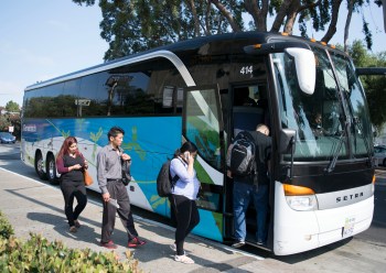 Employees board a shuttle bus headed to Genentech offices. Genentech drivers, along with others from companies like Zynga and Apple, work for Compass Transportation. Drivers are seeking union representation through the Teamsters for contracts with better wages and benefits. (Photo by Erasmo Martinez/Bay News Rising)