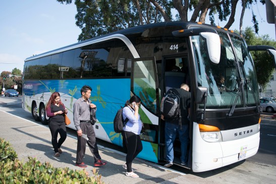 Employees board a shuttle bus headed to Genentech offices. Genentech drivers, along with others from companies like Zynga and Apple, work for Compass Transportation. Drivers are seeking union representation through the Teamsters for contracts with better wages and benefits. (Photo by Erasmo Martinez/Bay News Rising)