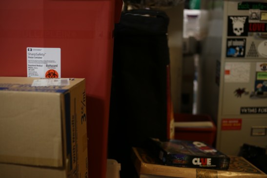 A sharps container is stored next to a stack of board games in the basement of Haight resident Kathleen Ryan on June 22, 2016. Ryan offered her home up to the Homeless Youth Alliance as a temporary office space after the non-profit has been unable to secure a new lease. Photo by Kelsey Lannin 