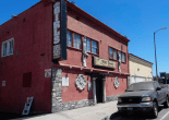 The exterior of a two-story building, which has a sign that reads "topless girls"